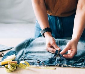 woman-repairs-sews-reuses-fabric-from-old-denim-clothes-economical-reuse